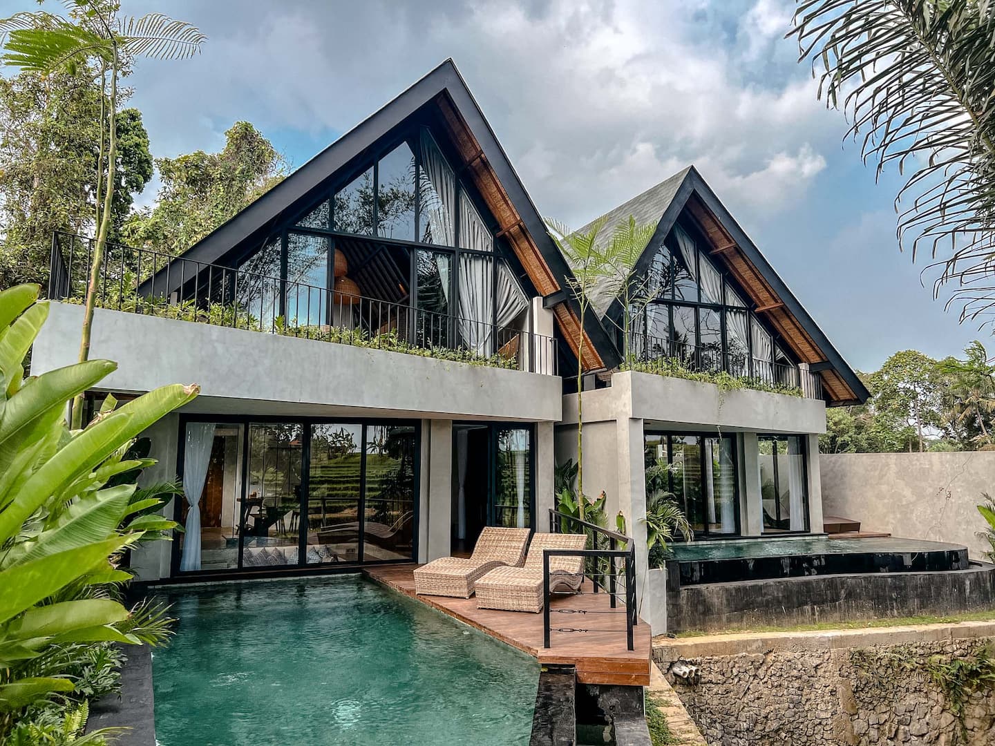 Twin A-frame gables of Villa Astu under palms