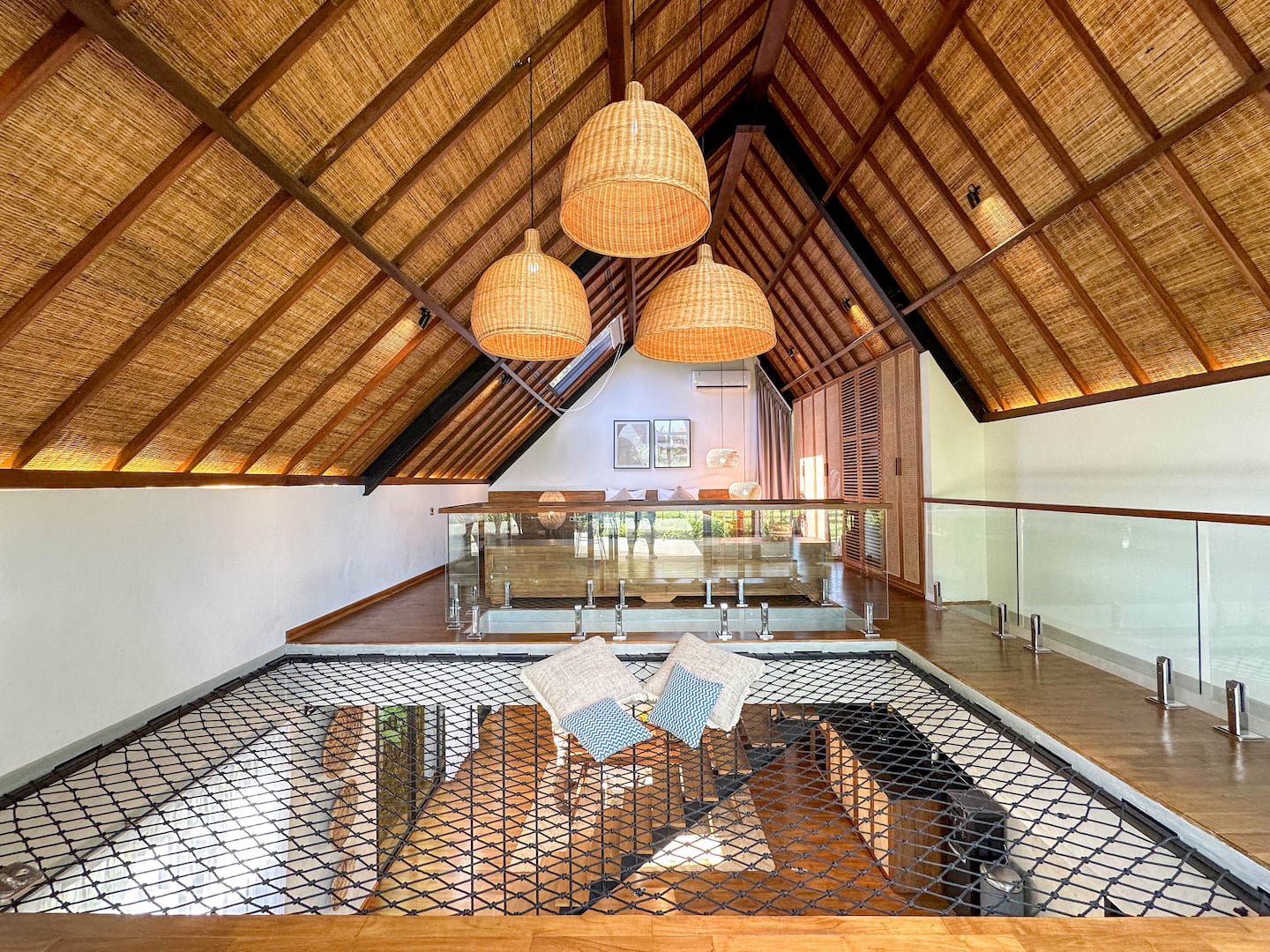 Suspended net lounge under the woven bamboo A-frame roof