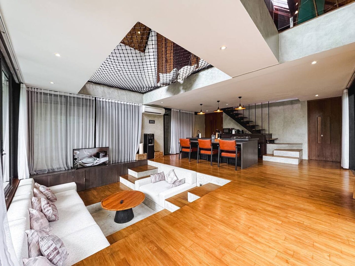 Living room with the mezzanine above and the kitchen behind