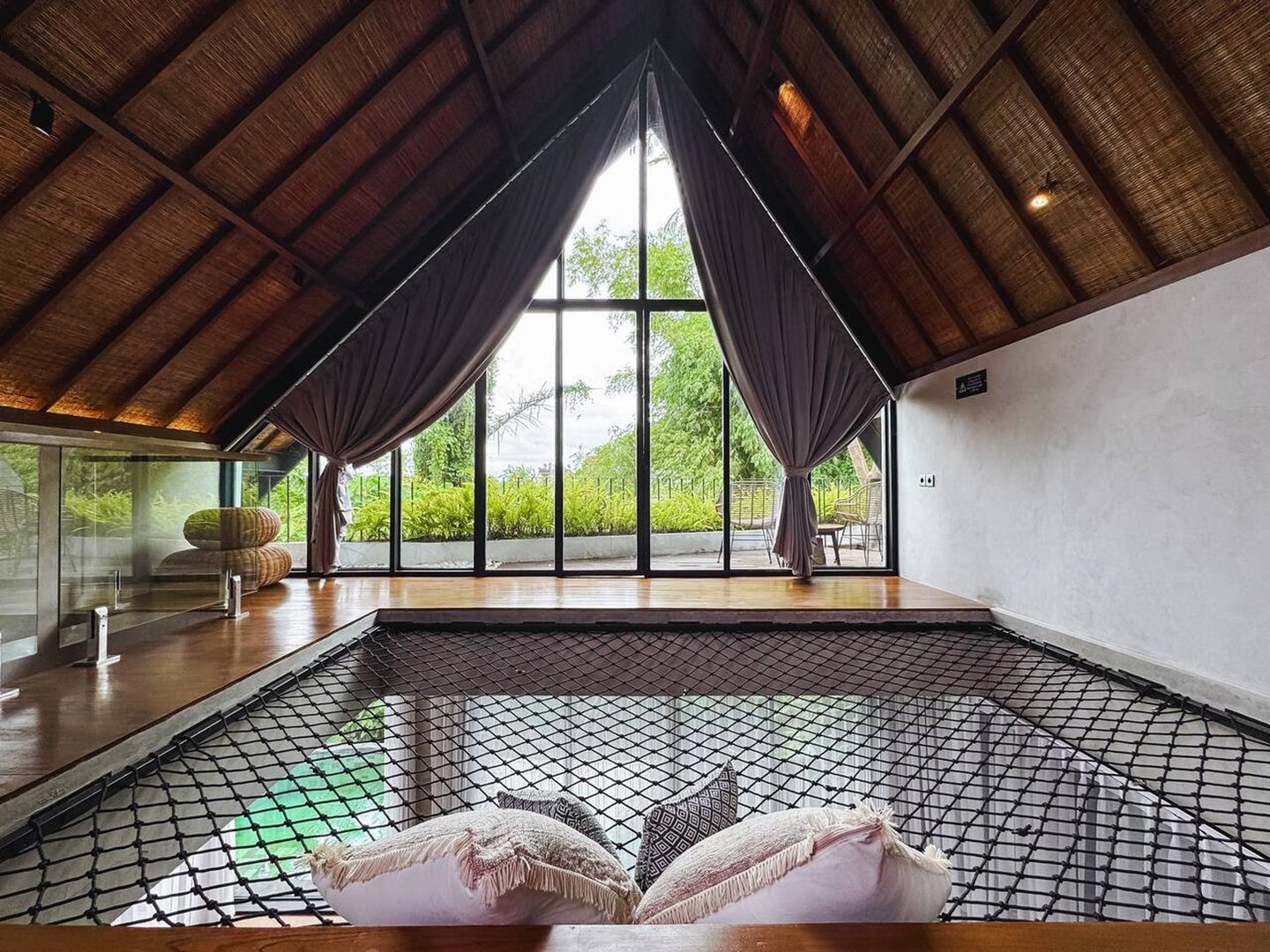 Suspended net under the gable, rice fields beyond the glass